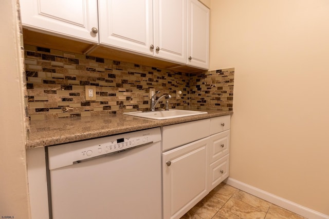 kitchen featuring baseboards, decorative backsplash, dishwasher, white cabinetry, and a sink