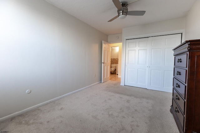 unfurnished bedroom with carpet floors, a ceiling fan, baseboards, and a closet