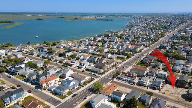 drone / aerial view featuring a residential view and a water view