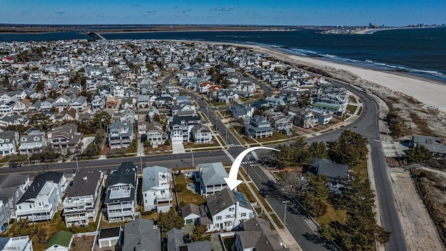 drone / aerial view with a water view, a residential view, and a view of the beach