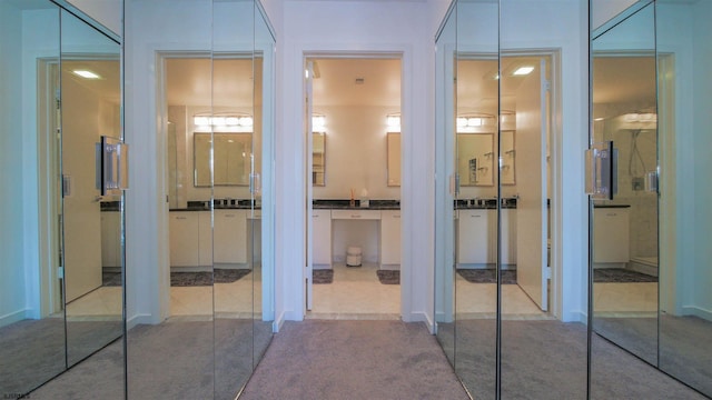 hall featuring carpet floors and tile patterned floors