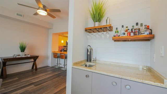 bar featuring a sink, a ceiling fan, visible vents, wet bar, and dark wood-style floors