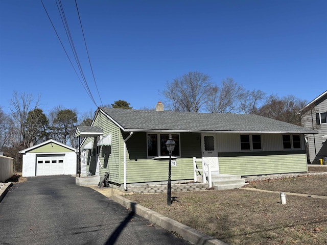 view of front of home with aphalt driveway, a porch, an outdoor structure, a detached garage, and roof with shingles