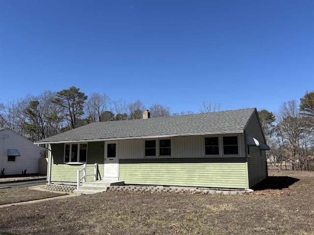 view of front of house featuring a shingled roof and a chimney