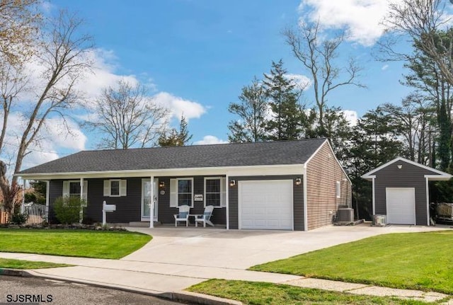 single story home with covered porch, concrete driveway, an attached garage, a front yard, and central AC