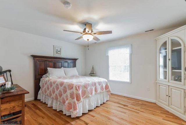 bedroom featuring light wood-style flooring, visible vents, and baseboards