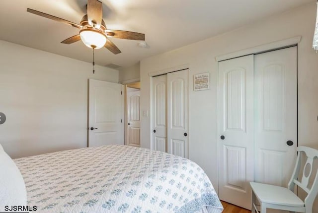 bedroom with two closets and a ceiling fan