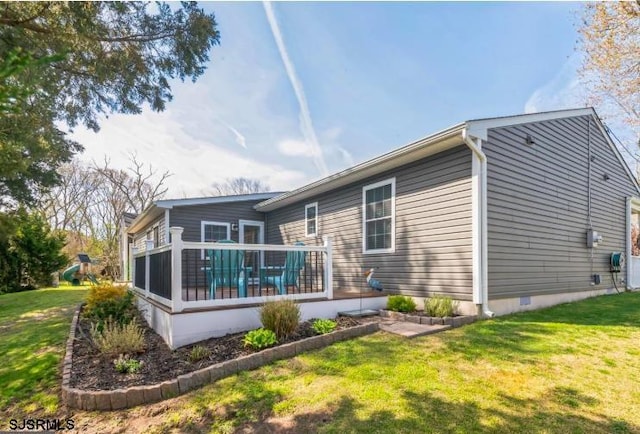 rear view of property with a yard, crawl space, and a sunroom