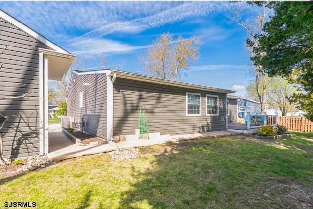 rear view of property with a patio area, fence, a deck, and a yard