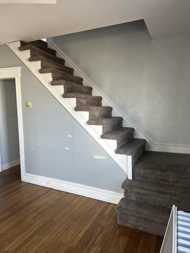 stairway with baseboards and hardwood / wood-style floors