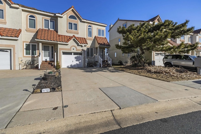 view of front of home with stucco siding, concrete driveway, and a tiled roof