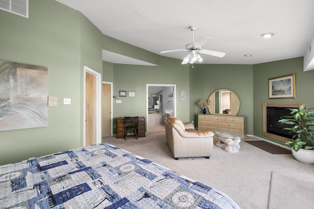 bedroom featuring lofted ceiling, ceiling fan, visible vents, carpet, and a glass covered fireplace