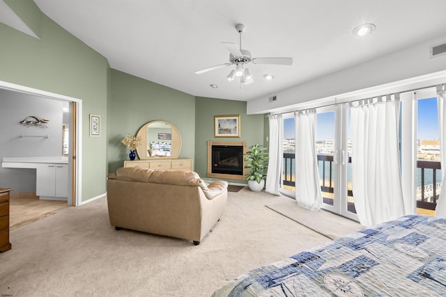 living room with carpet, a glass covered fireplace, a ceiling fan, and a healthy amount of sunlight