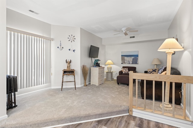 interior space featuring baseboards, carpet floors, visible vents, and a ceiling fan