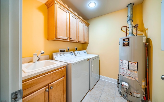 clothes washing area featuring cabinet space, washing machine and dryer, water heater, a sink, and light tile patterned flooring