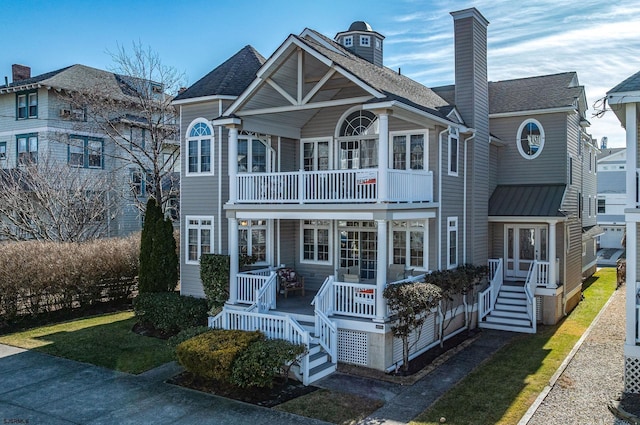 rear view of property with a shingled roof and a balcony