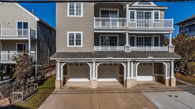 view of front of property with driveway, a garage, and roof with shingles