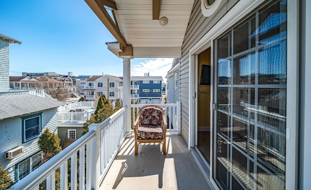 balcony featuring an AC wall unit and a residential view