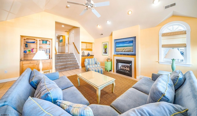 living area with stairs, a fireplace, tile patterned flooring, and lofted ceiling