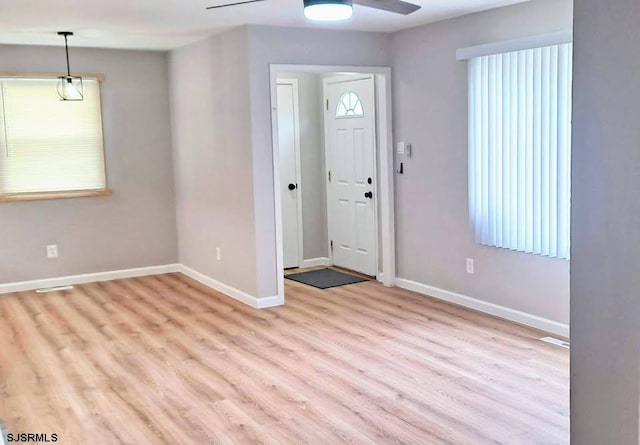 foyer featuring light wood-type flooring, ceiling fan, and baseboards