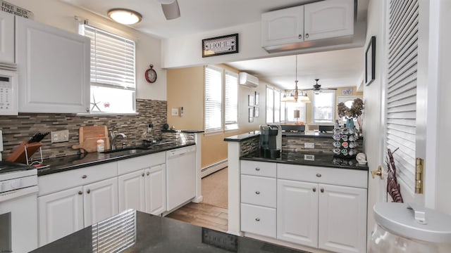 kitchen with white appliances, decorative backsplash, dark countertops, ceiling fan, and a sink