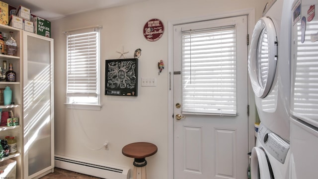 doorway to outside with a baseboard heating unit and stacked washer and clothes dryer