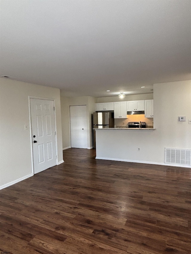 unfurnished living room featuring baseboards, visible vents, and dark wood-style flooring