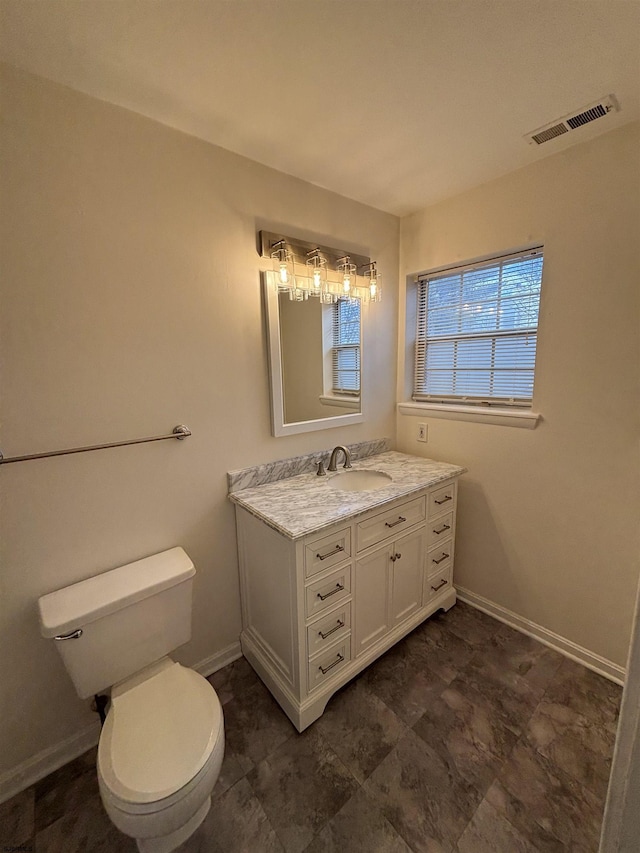 bathroom featuring baseboards, visible vents, vanity, and toilet