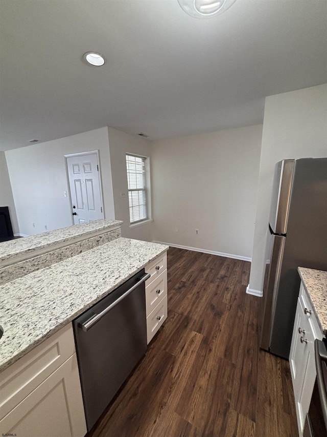 kitchen featuring stainless steel appliances, baseboards, white cabinets, light stone countertops, and dark wood-style floors