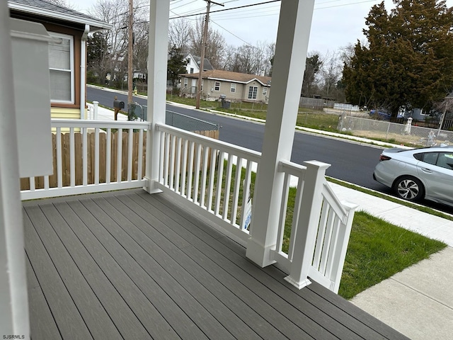 wooden terrace with a residential view and covered porch