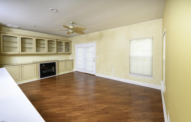 unfurnished living room featuring dark wood-style floors, wine cooler, a ceiling fan, and baseboards