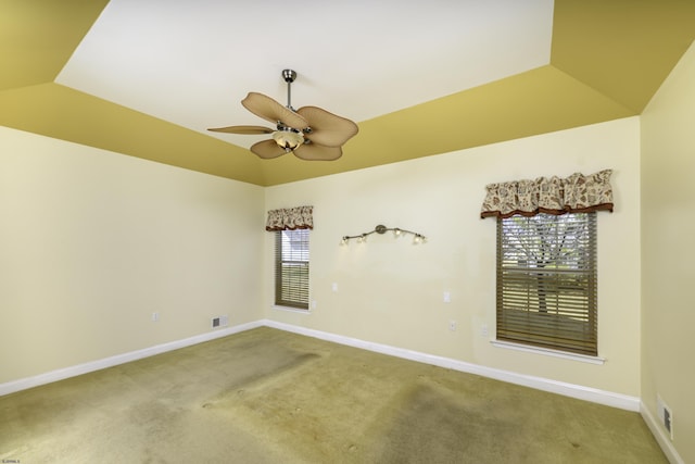 empty room featuring visible vents, carpet flooring, vaulted ceiling, ceiling fan, and baseboards