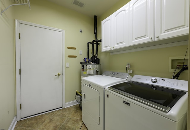 laundry area with washer and clothes dryer, visible vents, cabinet space, water heater, and tile patterned floors