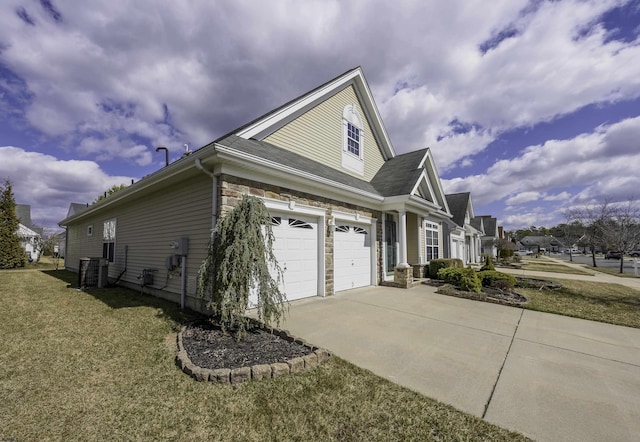 view of home's exterior featuring central AC unit, an attached garage, a yard, concrete driveway, and stone siding