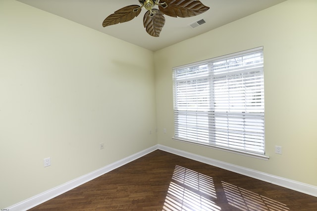 unfurnished room with dark wood-style floors, ceiling fan, visible vents, and baseboards