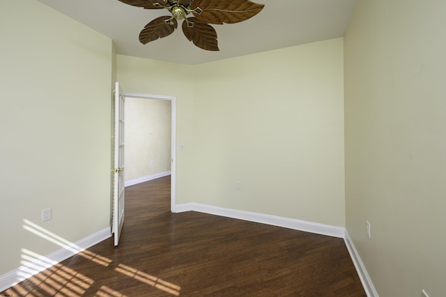 empty room with ceiling fan, baseboards, and dark wood finished floors