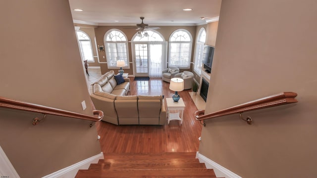 living room with baseboards, stairway, wood finished floors, and a healthy amount of sunlight