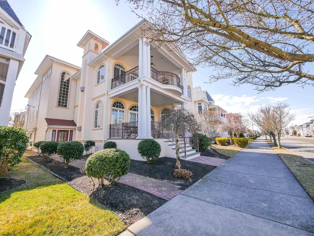 exterior space with covered porch, a balcony, and stucco siding