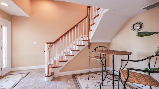 tiled foyer featuring stairway, baseboards, and visible vents