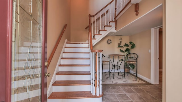 stairs featuring tile patterned flooring and baseboards