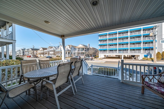 wooden deck featuring outdoor dining space and a residential view