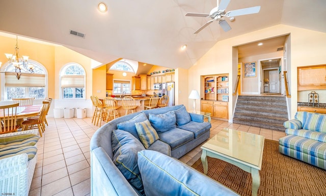 living room featuring visible vents, stairs, light tile patterned flooring, vaulted ceiling, and ceiling fan with notable chandelier