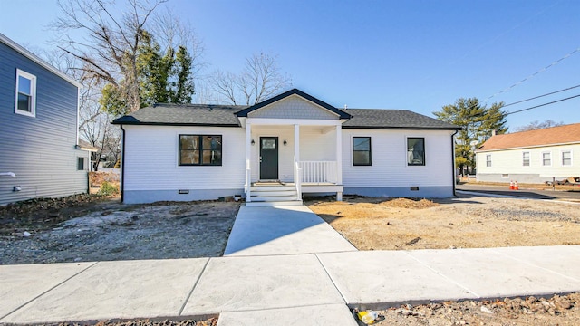 view of front of property featuring covered porch, roof with shingles, and crawl space