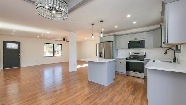 kitchen featuring light wood finished floors, appliances with stainless steel finishes, gray cabinets, and open floor plan