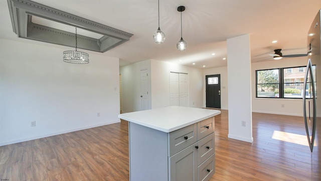 kitchen with open floor plan, hanging light fixtures, wood finished floors, and freestanding refrigerator