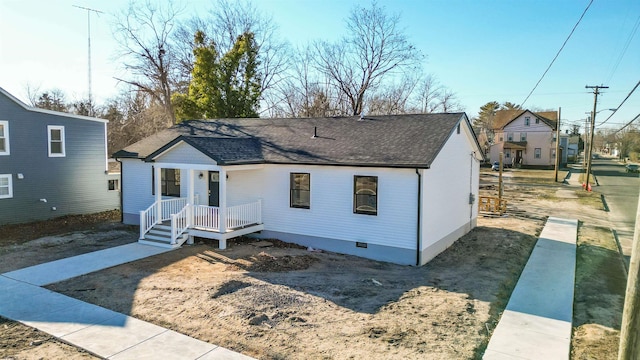 view of front of house with crawl space and a shingled roof