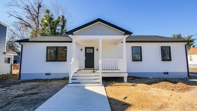 bungalow-style home featuring covered porch, roof with shingles, and crawl space