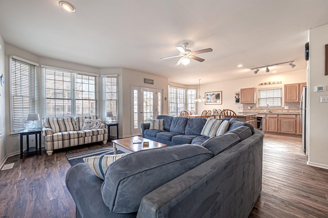 living area featuring a ceiling fan, baseboards, and wood finished floors