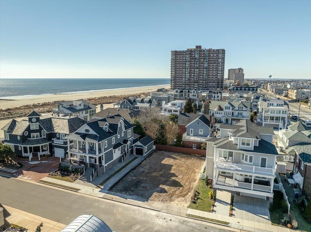 drone / aerial view featuring a beach view and a water view