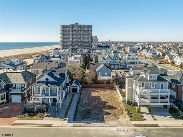 drone / aerial view with a residential view, a view of the beach, and a water view